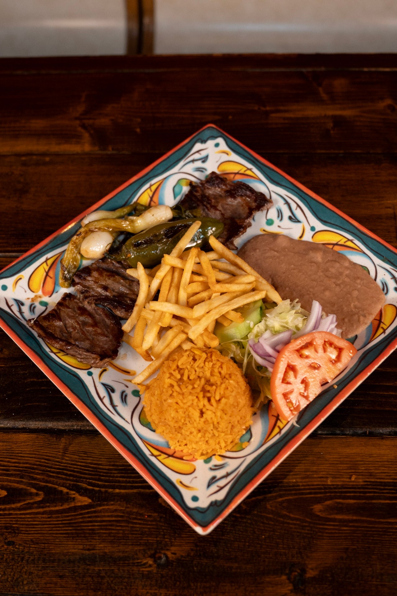 Carne asada plate with rice, beans, and grilled onions